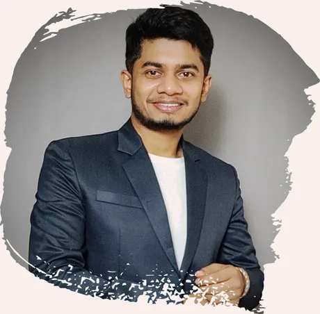 Portrait of Anirban Dam smiling, wearing a navy blazer over a white t-shirt
